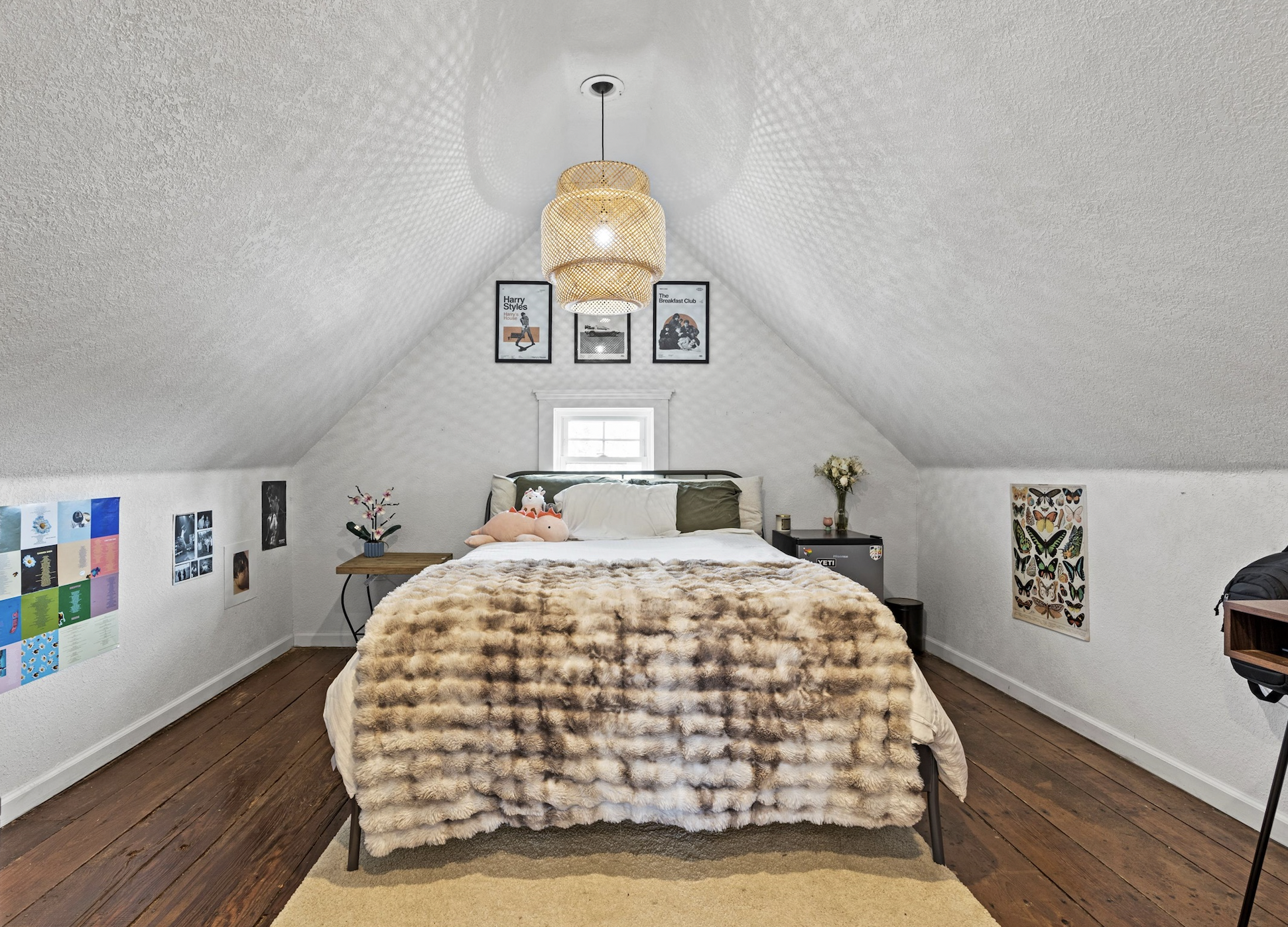 Picture of a third floor bedroom with bed and photos on the wall.